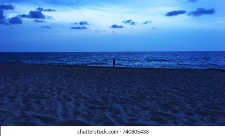 Little girl walking along the beach at night