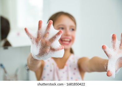 Little Girl Washing Hands With Water And Soap In Bathroom. Happy Kid Showing Soapy Palms. Hands Hygiene And Virus Infections Prevention. 