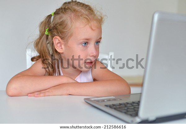 Little girl watching\
cartoons at computer.