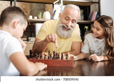 Little Girl Watching Her Brother And Grandfather Play Chess