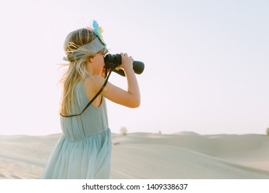 Little girl watching through the binoculars in the desert - Powered by Shutterstock