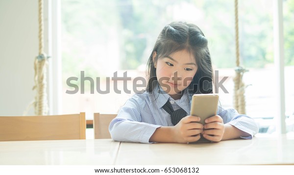 Little Girl Watching TV\
on a Smartphone