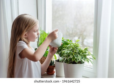 Little Girl Watering Houseplants In Her House