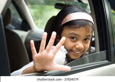 Little Girl Waving Goodbye From Inside Of A Car