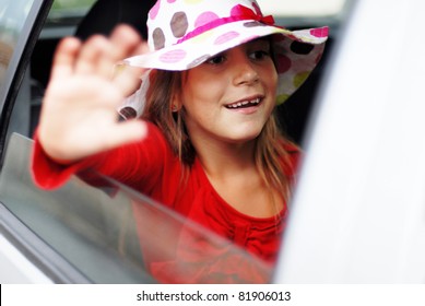 Little Girl Waving Goodbye From Inside Of A Car