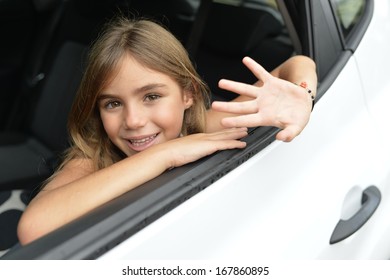 Little Girl Waving Hand By Car Window