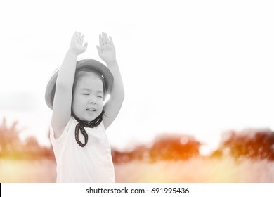 Little girl wear helmet and praying and raise hands in the morning for faith, spirituality and religion.Trust ind GOD concept.