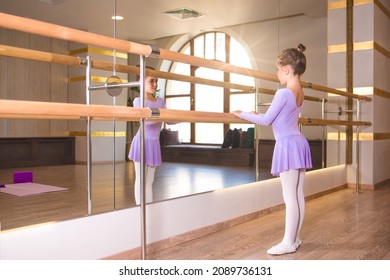 little girl wear pointe in ballet class near frame and large mirror - Shutterstock ID 2089736131