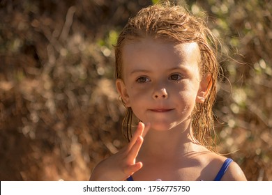 A Little Girl With Wet Hair On The Beach In Summer