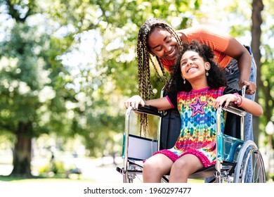 Little girl in a wheelchair at the park with her mother. - Powered by Shutterstock