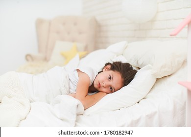 Little Girl Who Can't Sleep In Her Crib With Her Hands Under Her Head, Covered With A Warm Blanket. Healthy, Long-lasting Sleep For Children. Problems With Falling Asleep In The Evening.