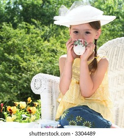 Little Girl In Wicker Chair Having Tea Party