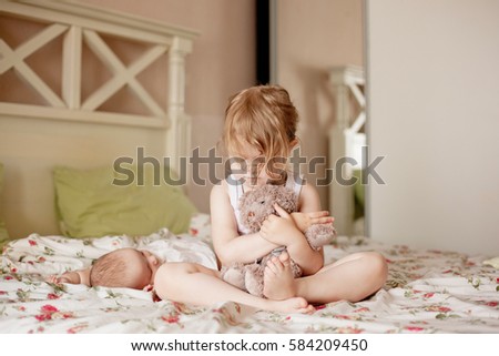 Similar – Baby girl reading book with family in the bed