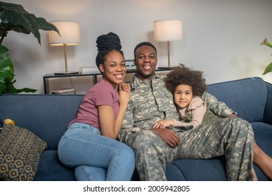 Little Girl Woman And Military Man Sitting On Couch