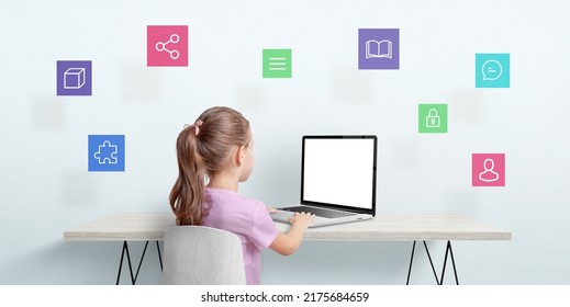 Little Girl Work On A Laptop Computer. Internet Of Things Concept. Isolated Laptop Display For Mockup. Icons Are Floating Above The Table