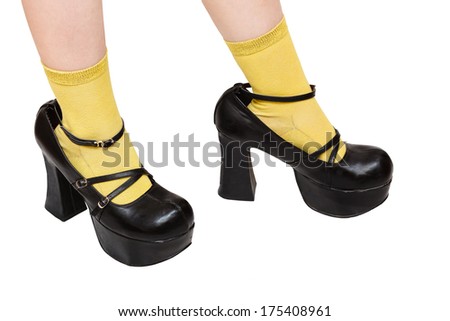 little girl in yellow socks trying on black platform shoes older sister