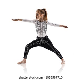 Little girl in a yoga pose with drawing skeleton.