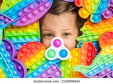 Little Girl,kid,child Head Among Many,lots Of Colorful Pop It. Children Play. Trendy Silicone Antistress Colorful Sensory Push Toy Popit. Flapping Fidget. Rainbow Color.Cure Of Autism.Stress Reliever.