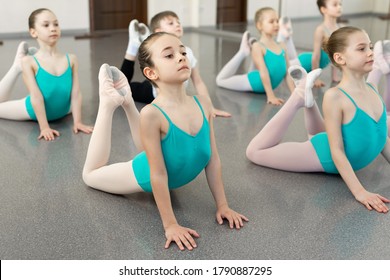 Little girls dancing ballet in studio. Young ballerinas stretching before performance, classical dance school