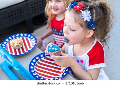 Little Girls Are Eating Cupcakes At July 4th Party.