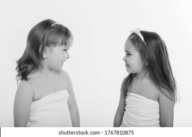 a little girls grimaces against a white background. The children is up to something. Concept of emotions , facial expressions, childhood, sincerity