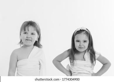 a little girls grimaces against a white background. The children is up to something. Concept of emotions , facial expressions, childhood, sincerity