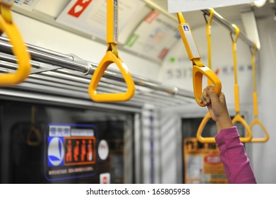 Little Girl's Hand Holding Subway Strap During Transportation