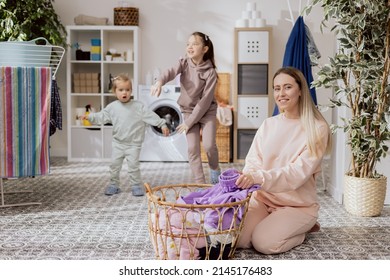 Little Girls Are Playing In The Bathroom, Laundry Room, Dancing, Running While Mom Is Busy Doing Chores, Folding Clothes, Preparing Things To Put In The Washing Machine.