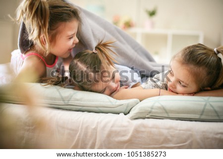 Similar – Children feeding doll with cookie sitting over the bed