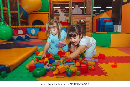 Little Girls Are Playing With A Construction Kit In The Playroom. Preschool Age.