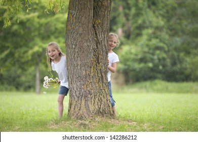 little girls playing hide and seek in the park