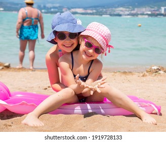kleine Mädchen, die auf einem Sandstrand spielen und in der Sonne sonnen