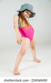 little girls posing in swimsuits and hat in studio. Fashion shot