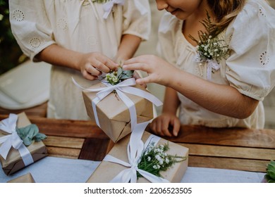 Little girls preparing gift for bride at wedding garden party. - Shutterstock ID 2206523505