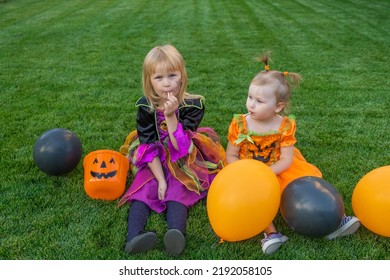 little girls and pumpkin candy bucket eating candy   celebrate Halloween