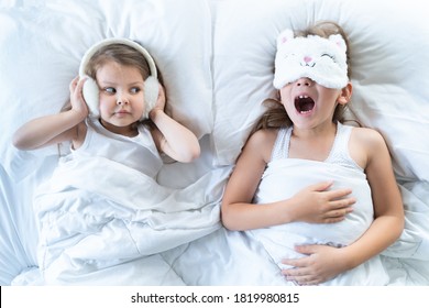 Little Girls Sleep In Bed. One Is Snoring Hard,sister Is Plugging Ears With Fur Headphones.Early Morning Wake Up,rise To Kindergarten,school. Bedtime,sweet Dreams.Kids Correct Daily Routine For Child.