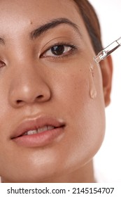 A Little Goes A Long Way. Shot Of A Beautiful Young Woman Posing With A Serum Dropper Against Her Face.