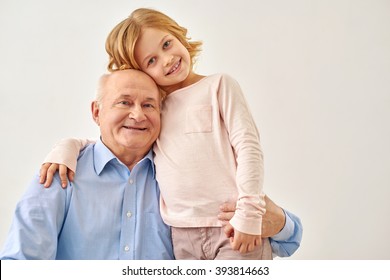 Little granddaughter hugging her grandfather