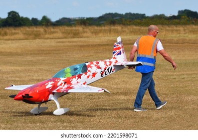 LITTLE GRANSDEN, CAMBRIDGESHIRE, ENGLAND - AUGUST 28, 2022: Large Radio Controlled Aircraft Being Pulled Accross Airfield.