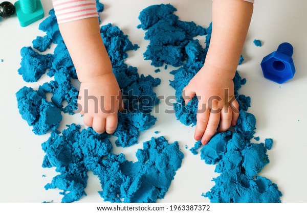 Little hands playing with kinetic sand.\
Educational games with kids for fine motor skills. Sand therapy\
indoors. Concept of sensory and creativity game, therapy hand,\
development of fine motor,\
autism