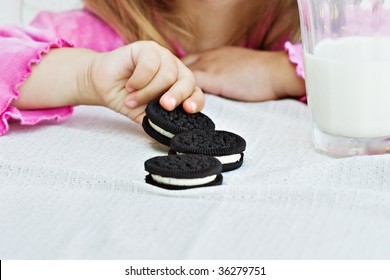 Little Hands Reaching For A Creme Filled Cookies.