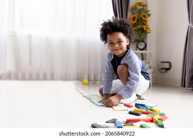 Little happy black people African American child playing with toys kid in the living room.

