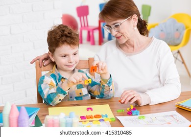 Little Happy Boy Having Classes With Occupational Therapist. Setting Words From Colorful Letters