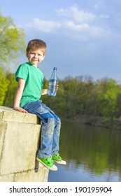 little happy boy holding a water bottle