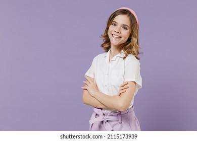 Little happy caucasian blonde kid girl 12-13 years old in white short sleeve shirt hold hands crossed folded isolated on purple color background children studio portrait. Childhood lifestyle concept - Shutterstock ID 2115173939
