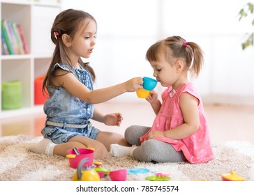 Little Happy Children, Cute Kids Girls Play With Plastic Toy Kitchen On Floor At Home Or Kindergarten