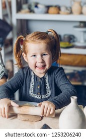 Little Happy Ginger Girl With Rolling-pin Working With Clay In The Craft Studio. Close Up Shot.childhood, Happiness Concept