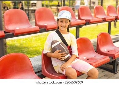 Little Happy Girl Holding Ball While Playing American Football In The Park. - Powered by Shutterstock