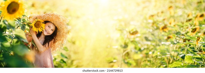 Little Happy Little Girl Playing Enjoying Sunflower Flowers On Sunny Summer Day Field. Spring And Summer Background Banner. Horizontal Photo Banner For Website Header Design.