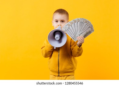 Little happy kid boy in yellow clothes hold fan of money in dollar banknotes, megaphone isolated on orange wall background, children studio portrait. Childhood lifestyle concept. Mock up copy space - Powered by Shutterstock